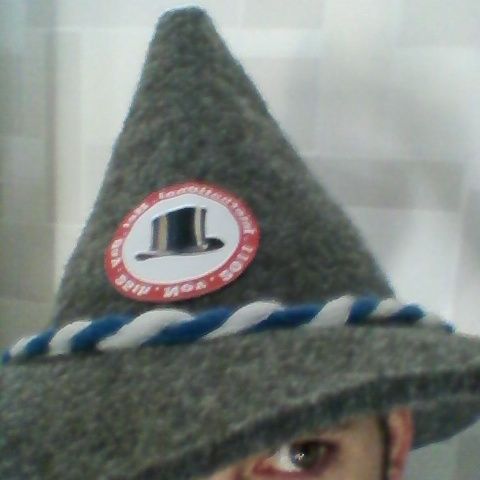 A grey felt alpine hat with a braided band and an IHD badge, pulled down over one eye