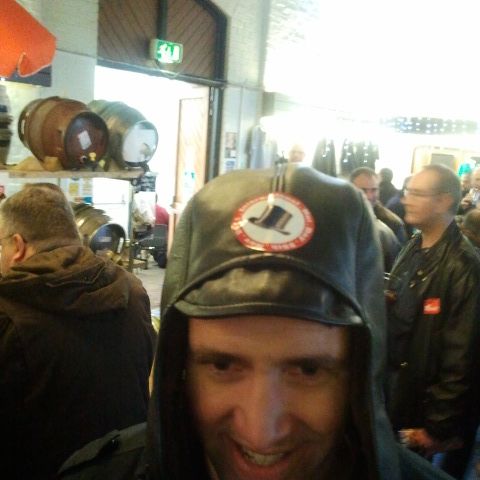 A man in a dark beanie with an IHD sticker on it, pulling a mock-serious face