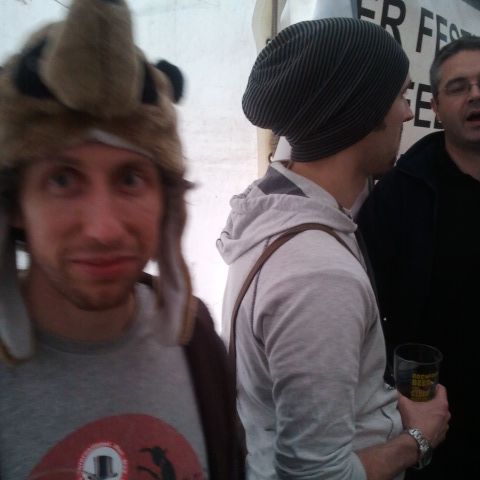 A man in a furry animal-ears hat with friends in beanies