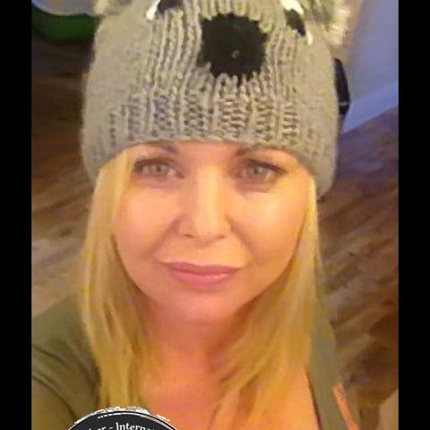 A woman in a knitted bear-ears hat, holding the 2012 logo