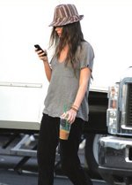 Someone in a striped fedora checking their phone