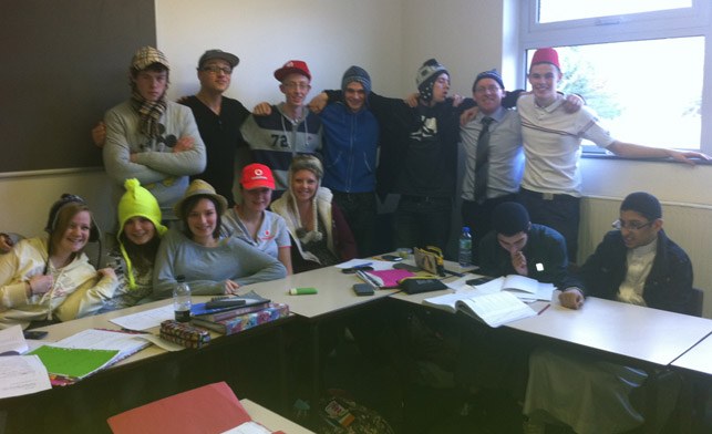 Turton Media Arts College students and staff posing indoors in a cheerful variety of hats, around 2010